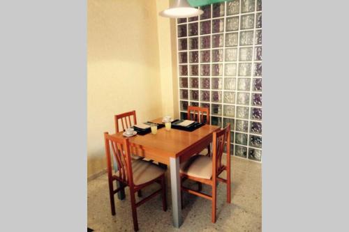 comedor con mesa de madera y sillas en Confortable-tranquilo apartamento junto al centro, en Málaga
