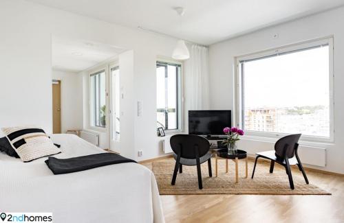 1 dormitorio blanco con 1 cama, mesa y sillas en 2ndhomes Tampere "Kanava" Apartment - 54m2 Apt with Private SAUNA & Balcony - 11th floor en Tampere