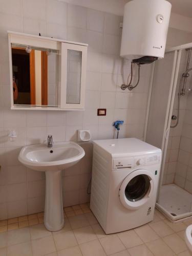 een badkamer met een wasmachine en een wastafel bij Arboriamar in Sorso