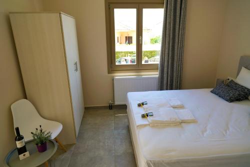 a bedroom with a white bed and a window at Charikleia's 2 bedroom appartment in Pelion in Volos