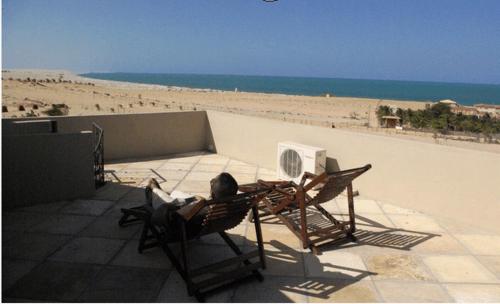 a person sitting in a chair on the beach at Pousada Aruana in Canoa Quebrada