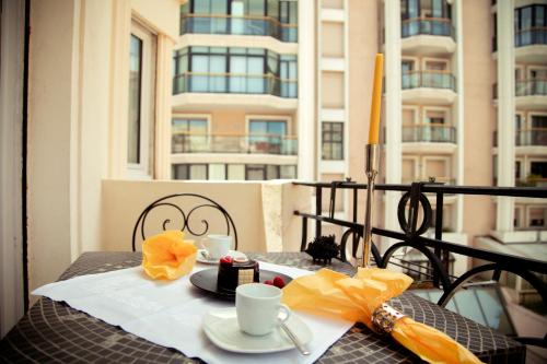 - une table avec 2 tasses et un gâteau sur le balcon dans l'établissement AnaZa Appartement, à Cannes