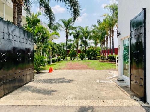 a driveway with palm trees in front of a building at Hotel Cascada in Cuautla Morelos