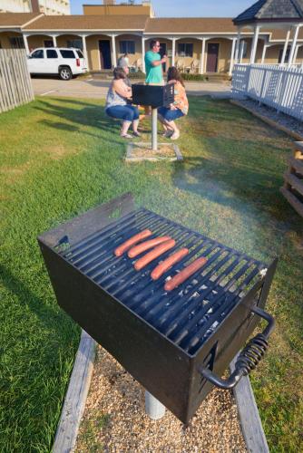 a grill with hot dogs on it in a yard at Outer Banks Motor Lodge in Kill Devil Hills