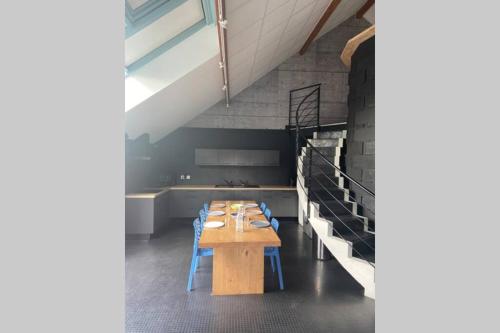 La Vie Est Belle في بواتييه: غرفة طعام مع طاولة خشبية وكراسي زرقاء