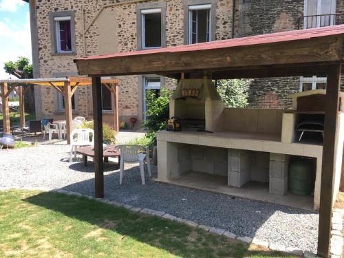 a patio with a grill in front of a building at Lime trees in Arnac-Pompadour
