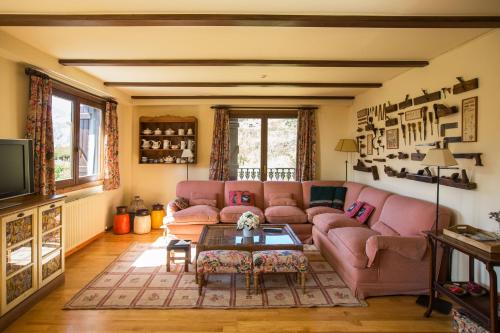 a living room with a pink couch and a table at Iron ✿ ❀ ✿ WiFi, 2 dormitorios y 2 baños in Formigal