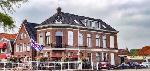a large brick building with a flag in front of it at Boutique Hotel Joure - centrum & haven in Joure
