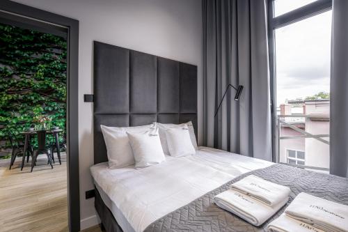 a bedroom with a large bed with a large window at Luxo apartments 13 in Jelenia Góra