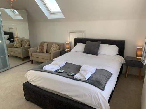 a bedroom with a large bed with towels on it at 3 Bedroom Detached Beach House Poole in Poole