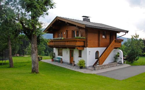 ein kleines Holzhaus mit Balkon auf einem Feld in der Unterkunft Ferienwohnung Gassoid in Fieberbrunn