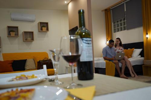 a man and woman sitting at a table with a bottle of wine at 7 days Apartment in Makó