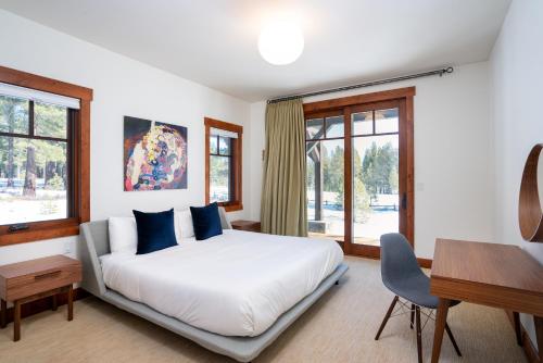 a bedroom with a bed and a desk and windows at New Listing! Luxury 3BD Residence on Gray's Crossing Golf Course in Truckee