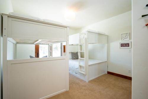 a bedroom with white bunk beds and a window at New Listing! Luxury 3BD Residence on Gray's Crossing Golf Course in Truckee