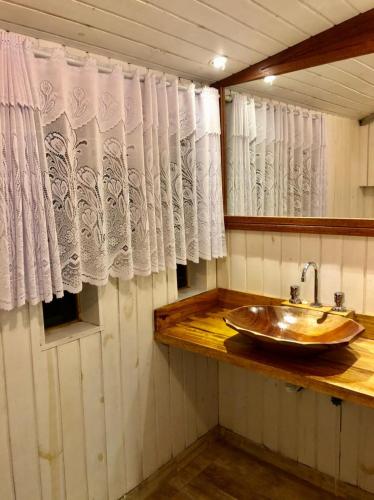 a bathroom with a wooden sink and a window at Pousada Casa da Vista in Visconde De Maua