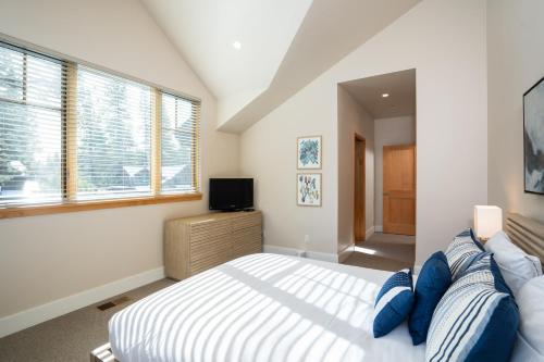 a bedroom with a large bed with blue pillows at NEW 4BD Residence in the Signature Home Collection at Old Greenwood! in Truckee