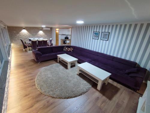 a living room with a purple couch and tables at A&S Villa Sarajevo in Hadžići