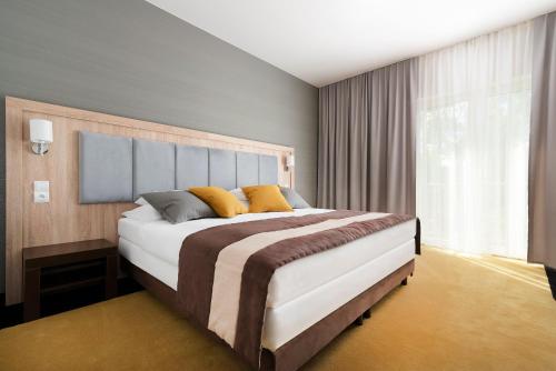 Un dormitorio con una cama grande y una ventana en Hotel & Spa Polesie en Białka