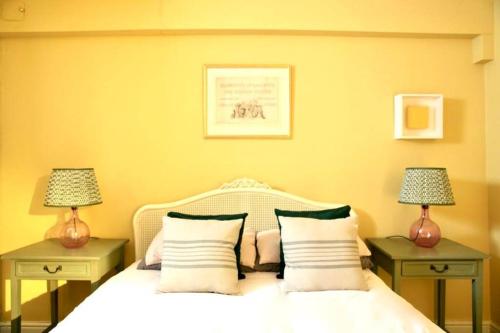 um quarto com uma cama branca com duas mesas de cabeceira em The Court Yard em Bowness-on-Windermere