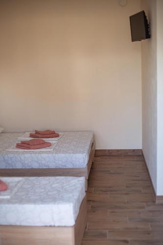two beds in a room with a tv on the wall at Estate House in Zatoka