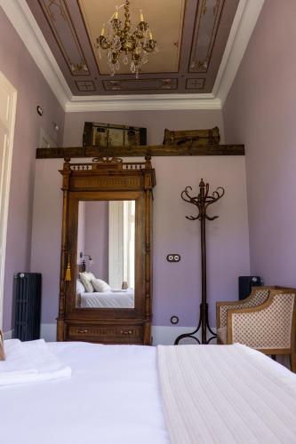 a bedroom with a mirror and a bed at La Venta de Miyares - Casa de Indianos in Piloña