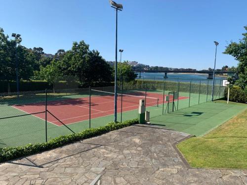 a couple of tennis courts next to the water at Plaza la Ria in Fonte Culler