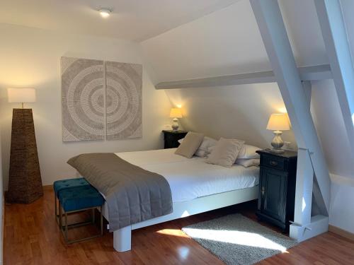 1 dormitorio con cama, mesa y lámpara en Gîte - Le Petit Noyer, en Le Bugue