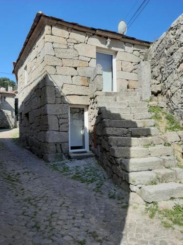 una casa in pietra con una porta in un muro di pietra di Casa do Doutor Palheiro a Travassos