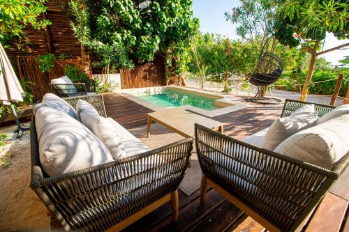 a patio with two chairs and a swimming pool at Spirit Holbox in Holbox Island