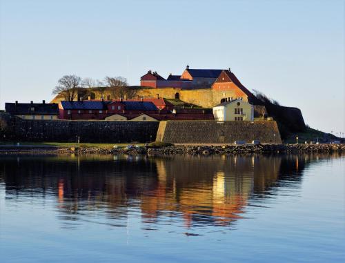 uma casa numa colina ao lado de um corpo de água em Fästningens em Varberg