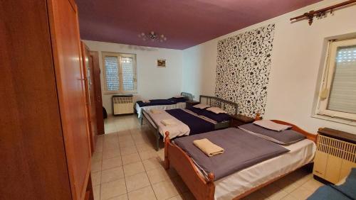 a bedroom with two beds and a window at Laci Szálláshely in Debrecen