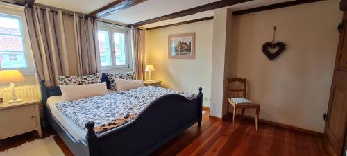 Un dormitorio con una cama azul y una ventana en Klosterküche en Quedlinburg