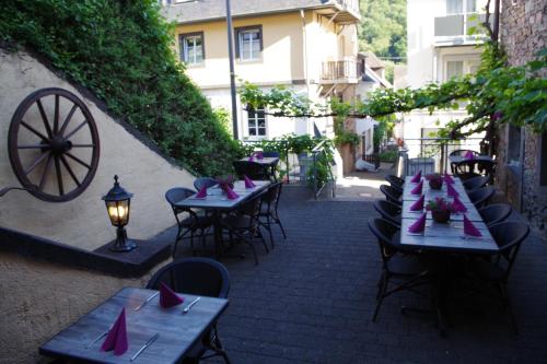 a row of tables and chairs with pink napkins at Gast und Weinhof Beim Schneemann in Valwig