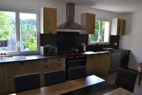 une cuisine avec des armoires en bois et un four à plaques de cuisson dans l'établissement Maison Cinona, à Le Mont-Dore