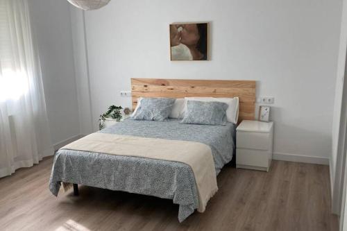 1 dormitorio con 1 cama grande y cabecero de madera en Apartamento nuevo, céntrico y tranquilo en Bullas