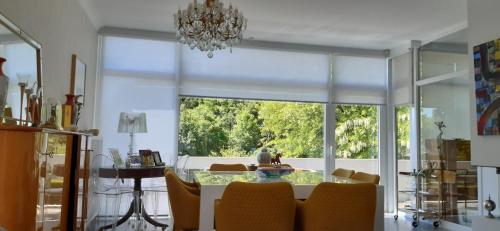 una sala da pranzo con tavolo e una grande finestra di Magnifique appartement- Brussels expo Laeken a Bruxelles