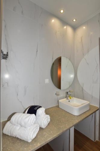 a bathroom with a sink and a mirror and towels at Gonis Grand Luxury Suite in Palaiochora