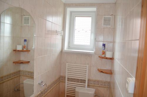a bathroom with a toilet and a window at vila Happy in Veľká Lomnica