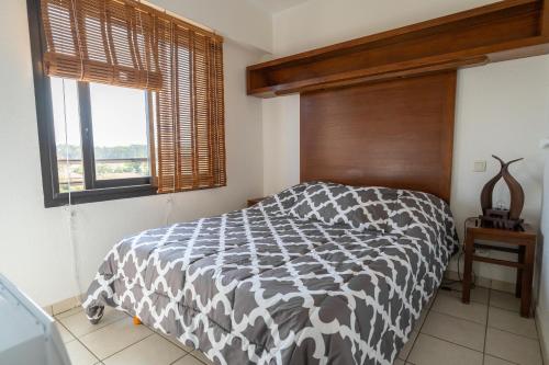 a bedroom with a black and white bed and a window at Résidence Lou Cout in Vieux-Boucau-les-Bains