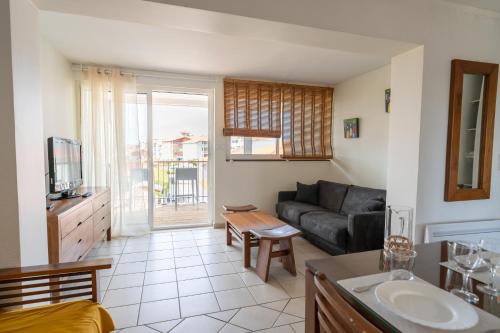 a living room with a couch and a table at Résidence Lou Cout in Vieux-Boucau-les-Bains