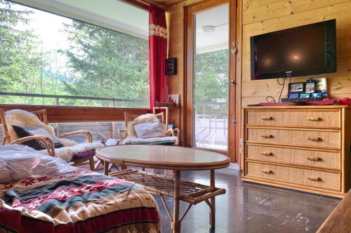 a living room with a table and a tv at The Chamroussian #BU in Chamrousse