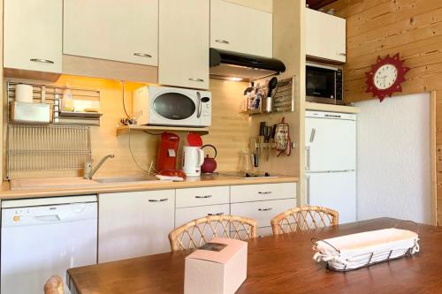 a kitchen with a dining table and a microwave at The Chamroussian #BU in Chamrousse
