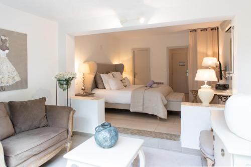 a living room with a bed and a couch at Hôtel Font Mourier in Cogolin