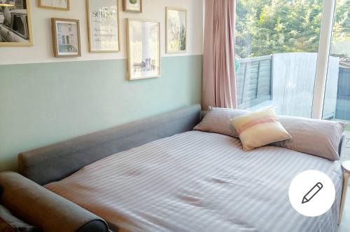 a bed in a bedroom with a large window at The Oldbrook Garden Flat in Milton Keynes