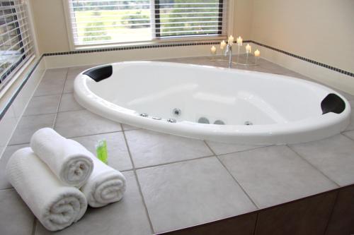 a white bath tub in a bathroom with towels at Yabbaloumba Retreat in Booloumba