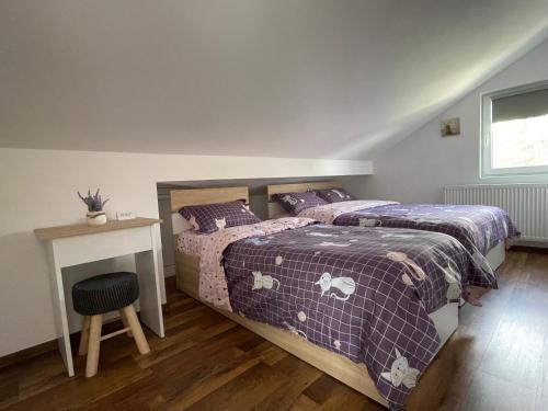 a bedroom with two beds and a table and a window at Casa Shiro in Sinaia
