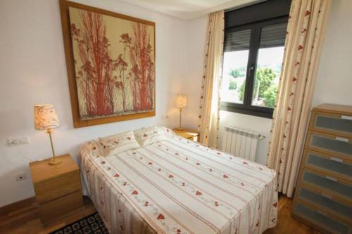 a bedroom with a bed and a painting on the wall at apartamento en ribadesella alta turismo VUT 265AS in Ribadesella
