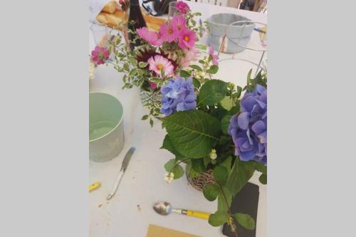 a table with a bunch of flowers on it at Penty bigouden 18ème classé 2** jardin en ville in Pont-lʼAbbé
