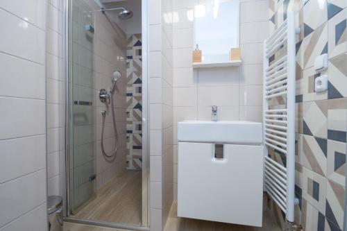 y baño blanco con lavabo y ducha. en Sunny apartment, en Olomouc