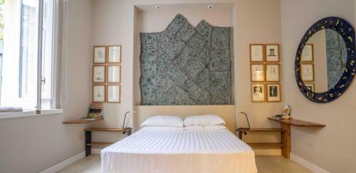 - une chambre avec un lit blanc et un miroir dans l'établissement Atelier Inès Arts & Suites, à Naples